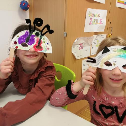 Zwei Mädchen mit Schmetterlings- und Katzenmaske